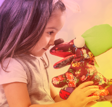 Niña jugando con dos tiburones títeres